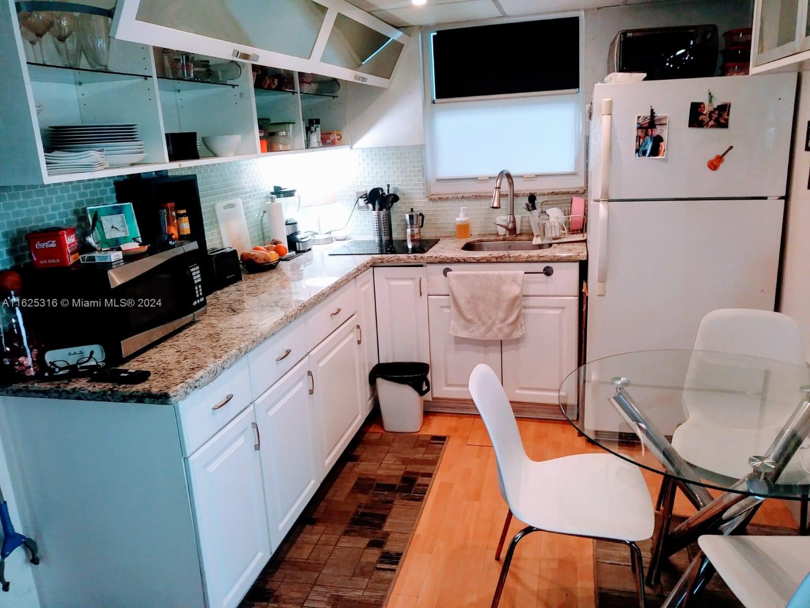 a kitchen with a white cabinets and chairs