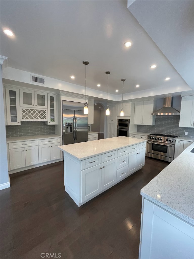a large kitchen with stainless steel appliances a large counter top a stove and a sink