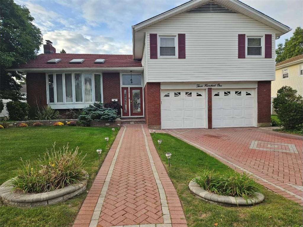 Tri-level home with a front yard and a garage