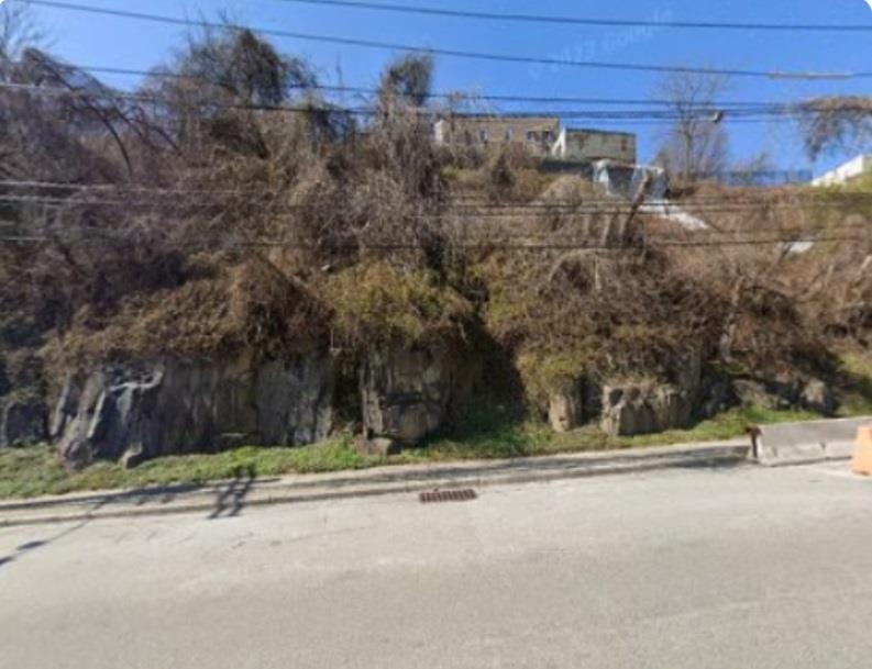 a view of a street with a bench in front of it