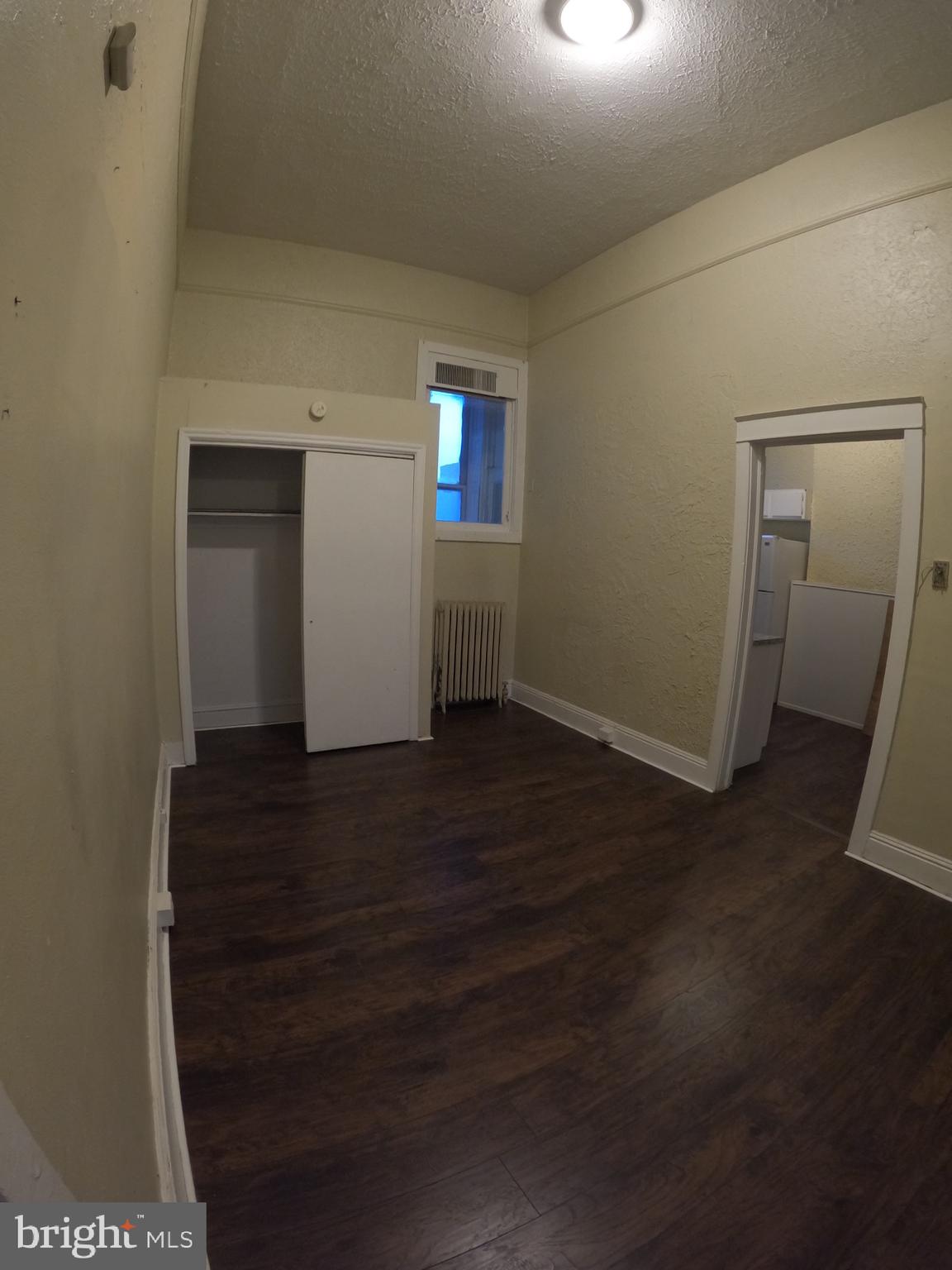 an empty room with wooden floor and closet