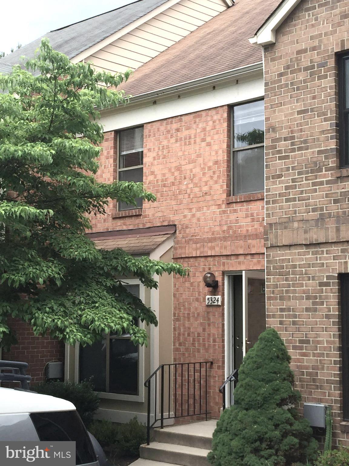 a front view of a house with plants