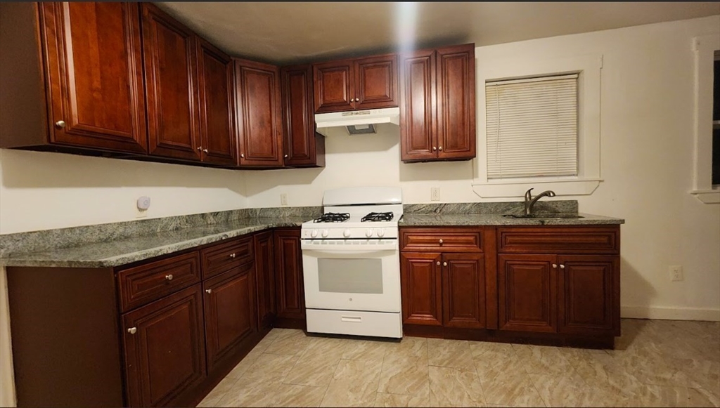 a kitchen with stainless steel appliances granite countertop a stove a sink dishwasher and a refrigerator