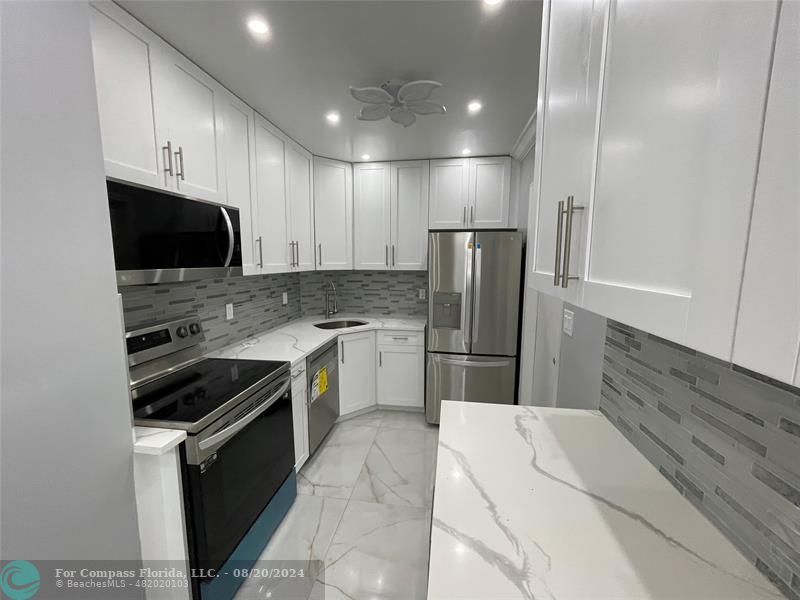 a kitchen with a refrigerator and a stove top oven