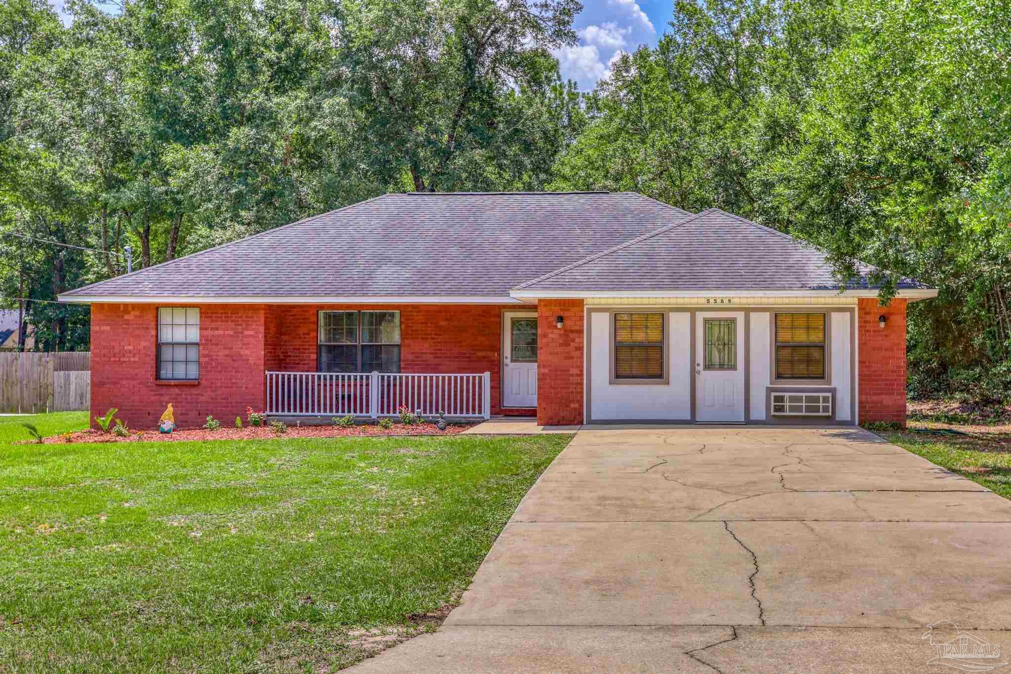 a front view of a house with a yard and trees