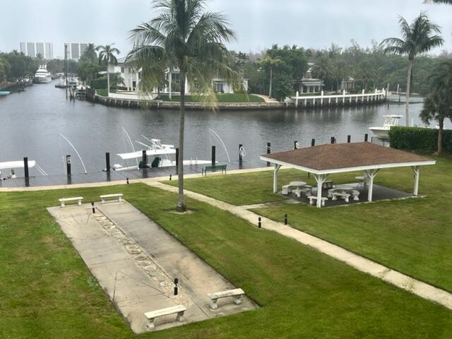 a view of a lake with a yard and large trees