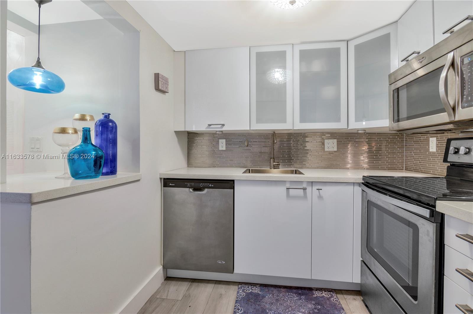 a kitchen with stainless steel appliances granite countertop a sink stove and microwave