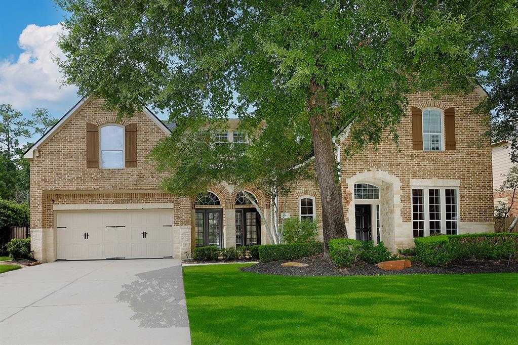 a front view of a house with a garden and trees