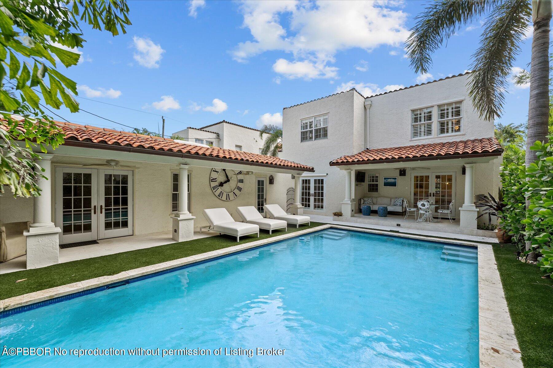 a front view of a house with swimming pool and furniture