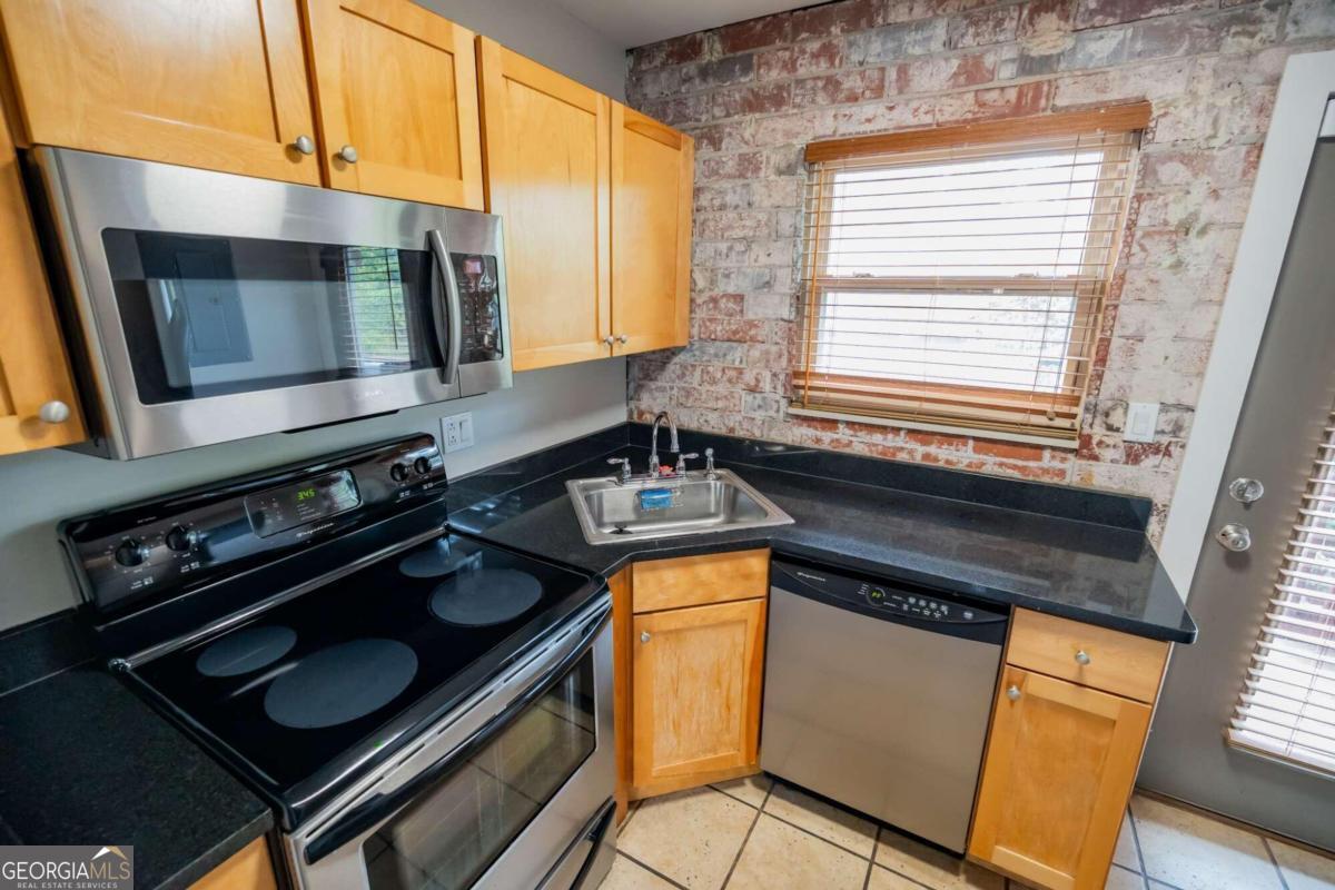 a kitchen with granite countertop stainless steel appliances a stove sink and microwave