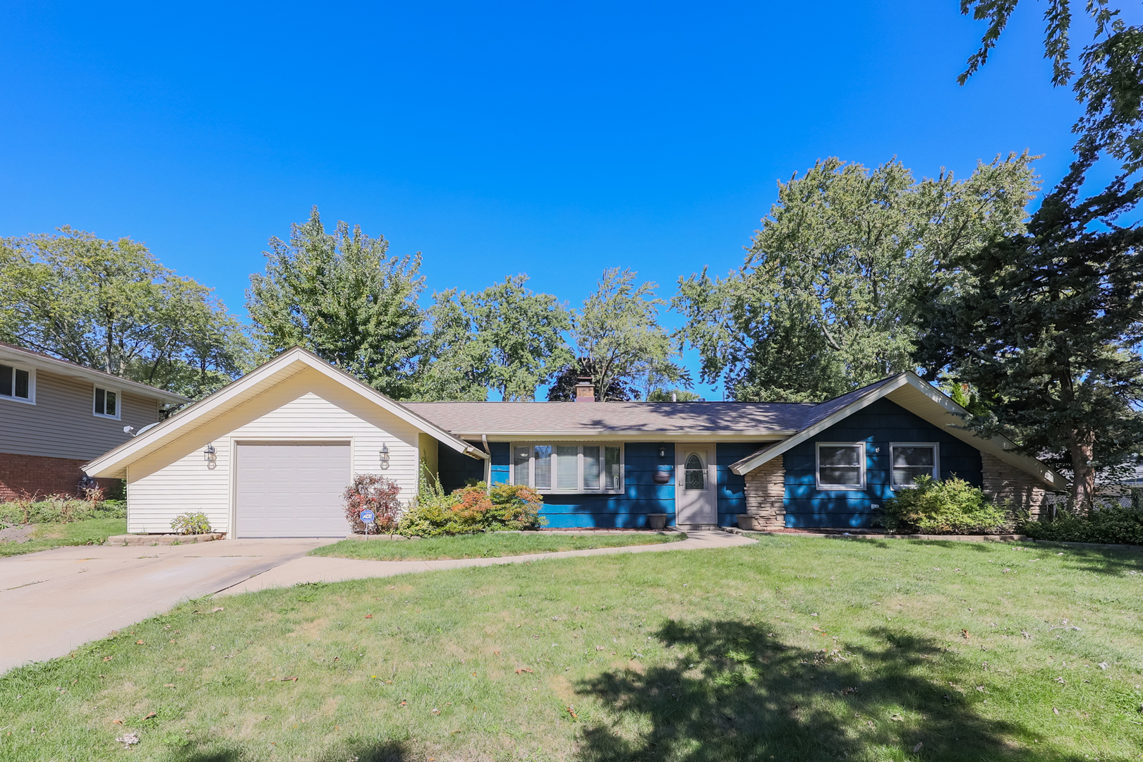 a front view of a house with a yard and trees