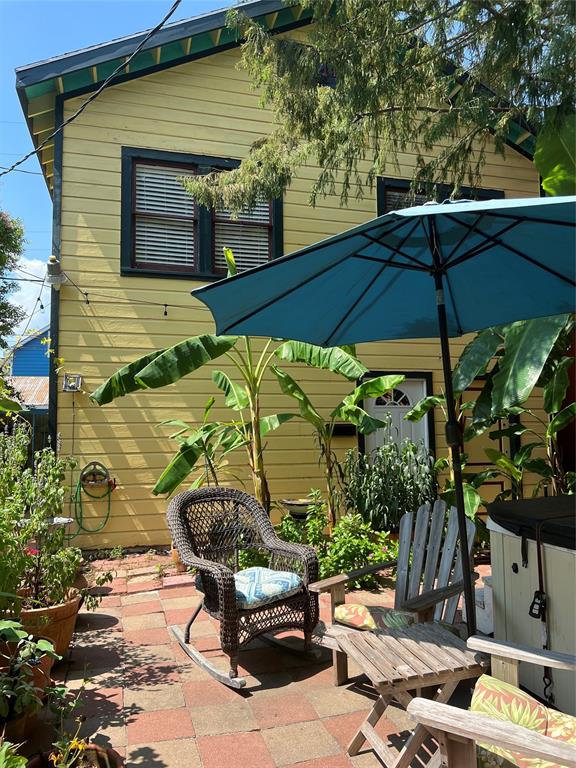 a view of a patio with table and chairs under an umbrella