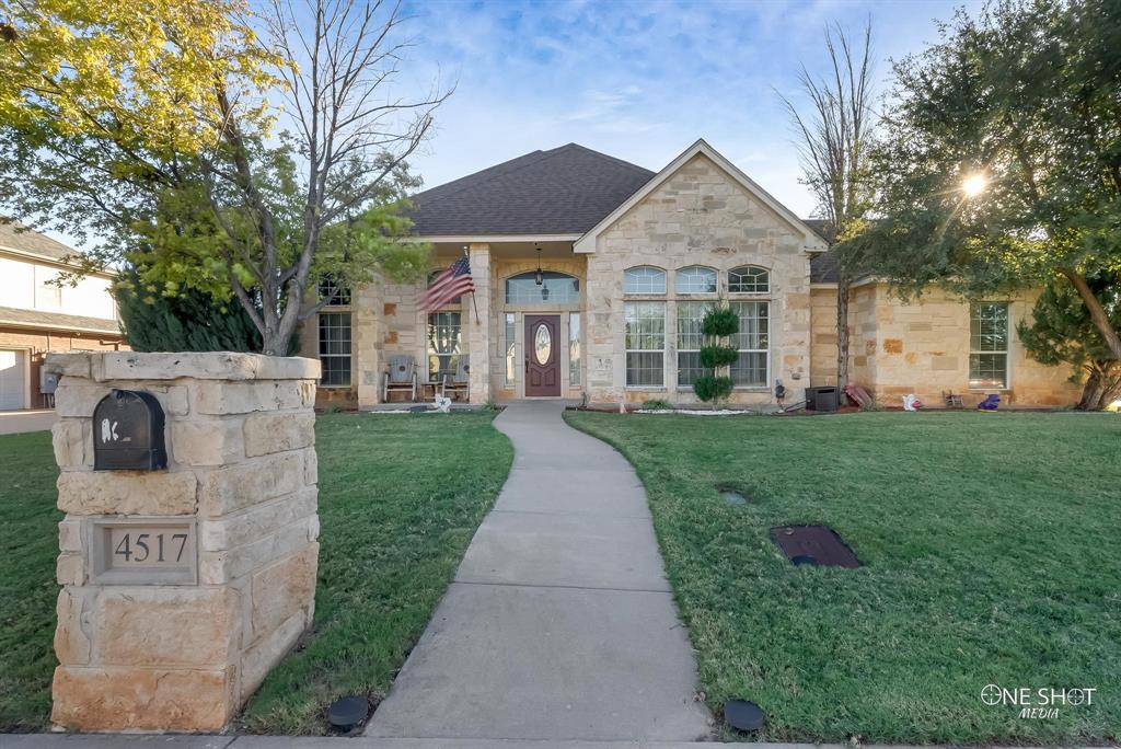 a front view of a house with a yard and garden