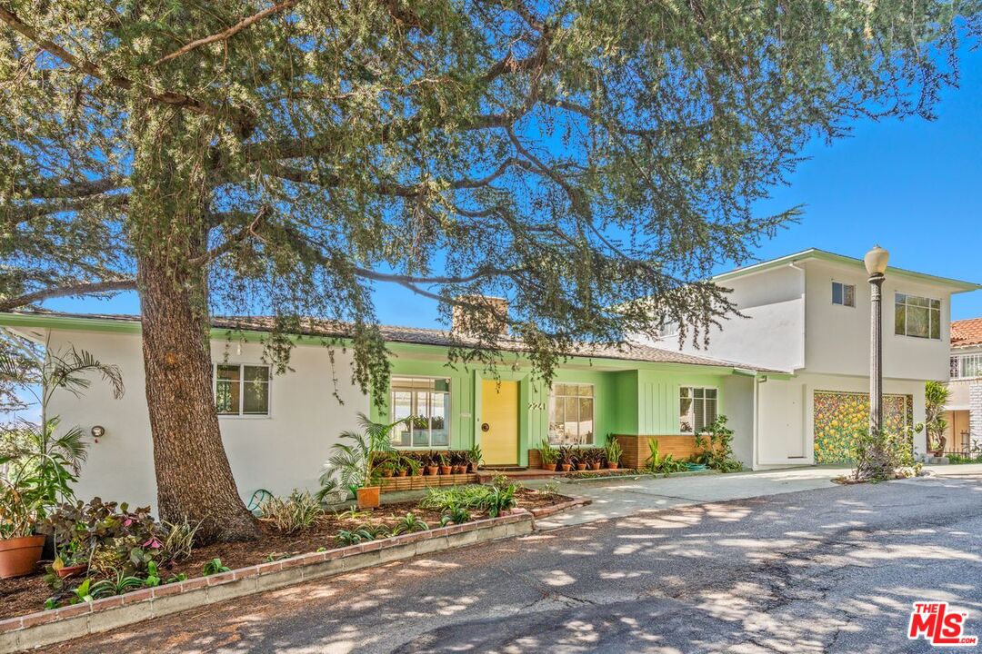 a view of a house with backyard and a tree