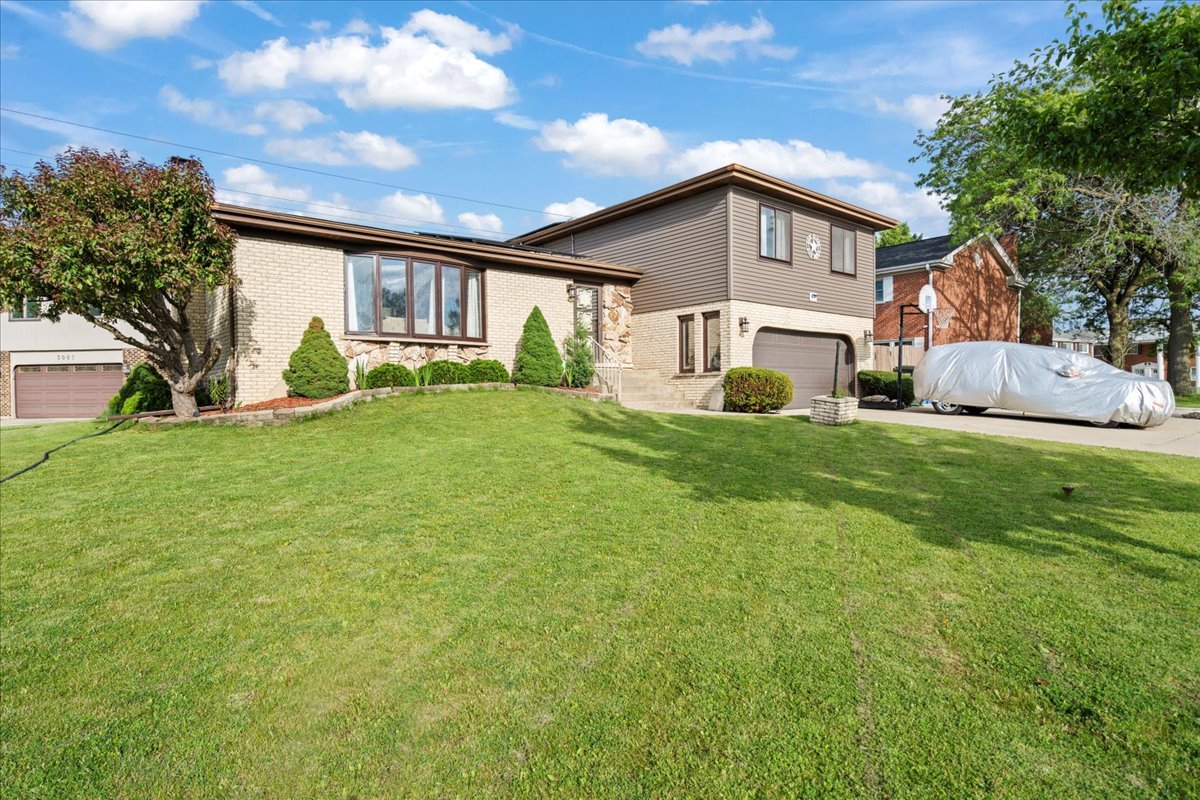 a view of a house with a big yard and large trees