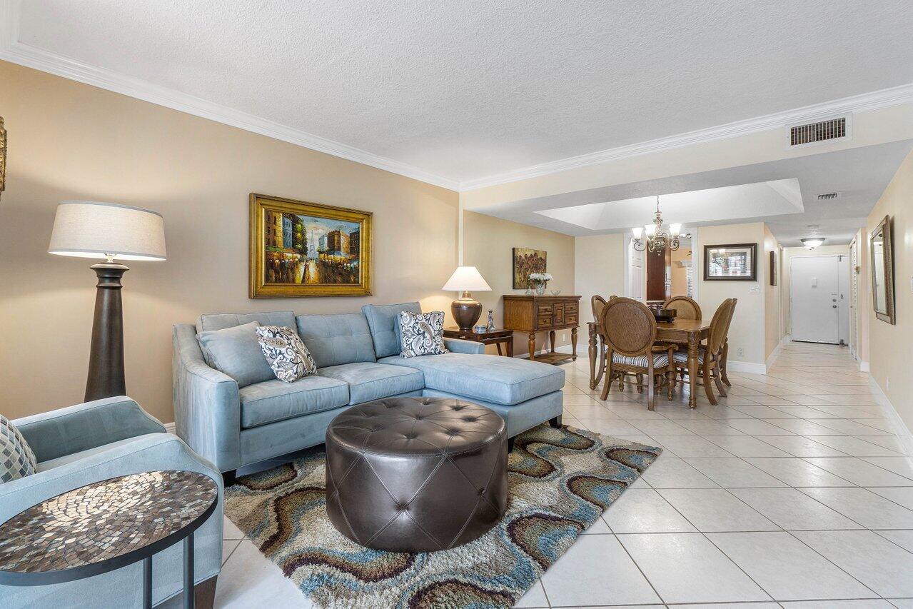 a living room with furniture a wooden floor and a lamp