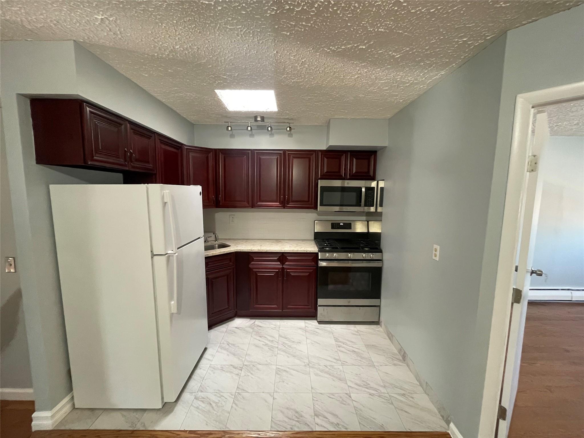 a kitchen with stainless steel appliances a refrigerator and a stove top oven