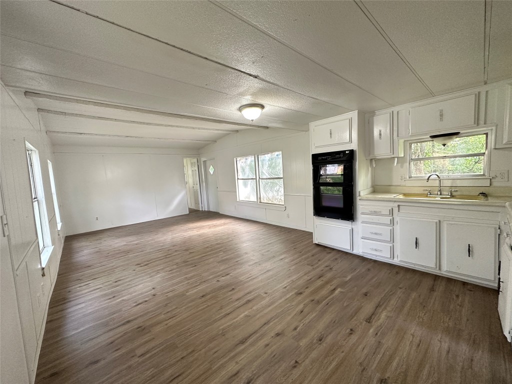 a view of a kitchen with wooden floor and electronic appliances