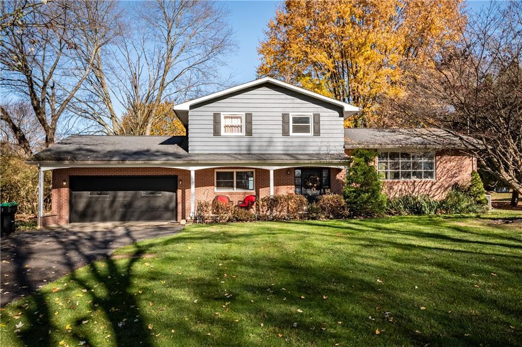 a view of a house with a yard and trees