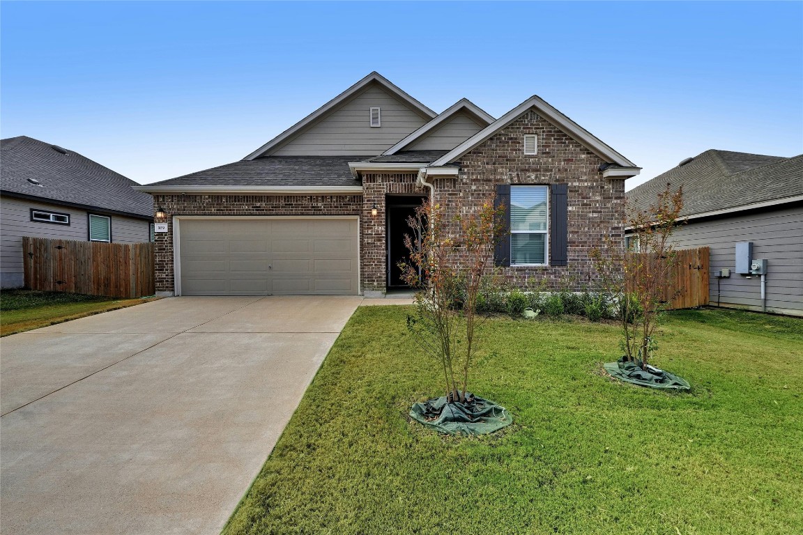 a front view of a house with a garden and yard