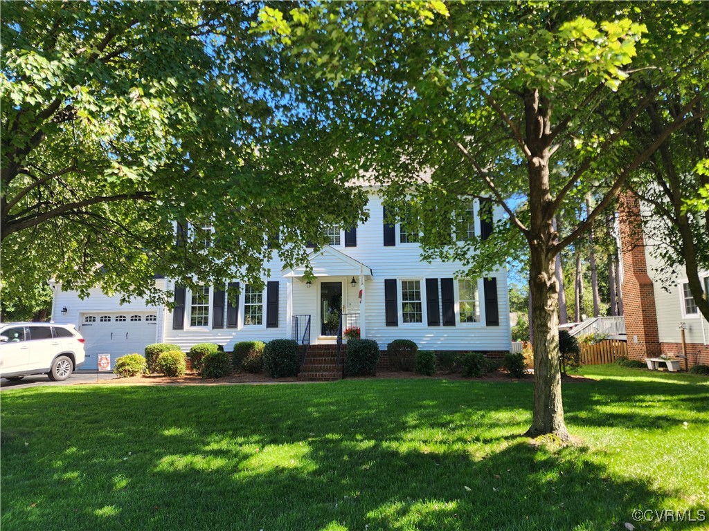 a front view of house with yard and green space