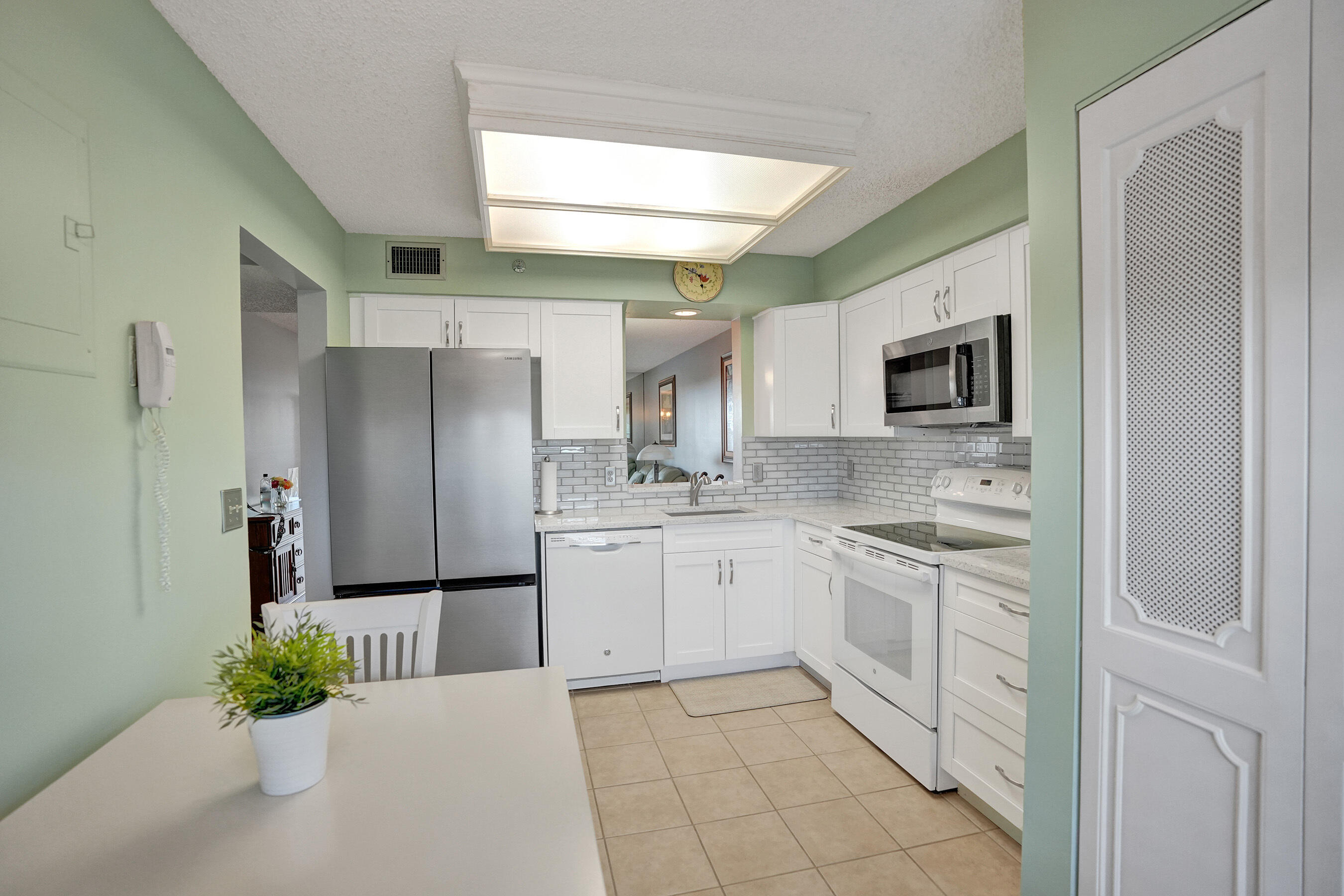 a kitchen with stainless steel appliances kitchen island granite countertop a refrigerator and a sink