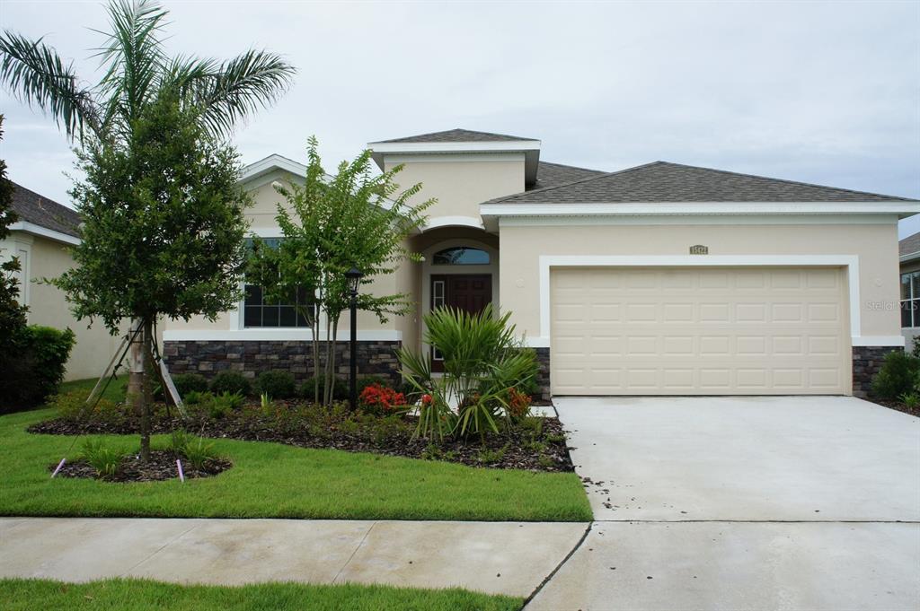 a front view of a house with a yard and garage