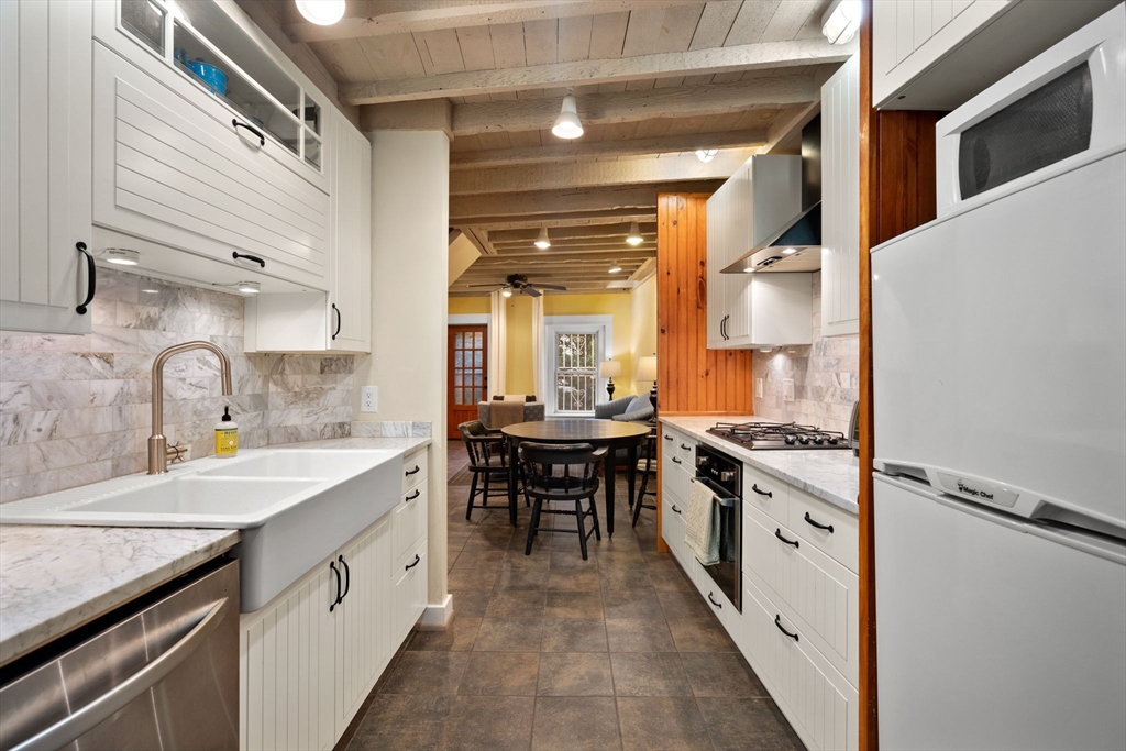 a large kitchen with granite countertop a sink and a stove