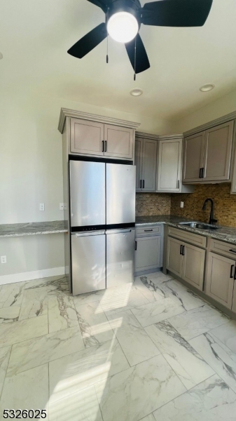 a kitchen with granite countertop a sink a counter top space cabinets and stainless steel appliances