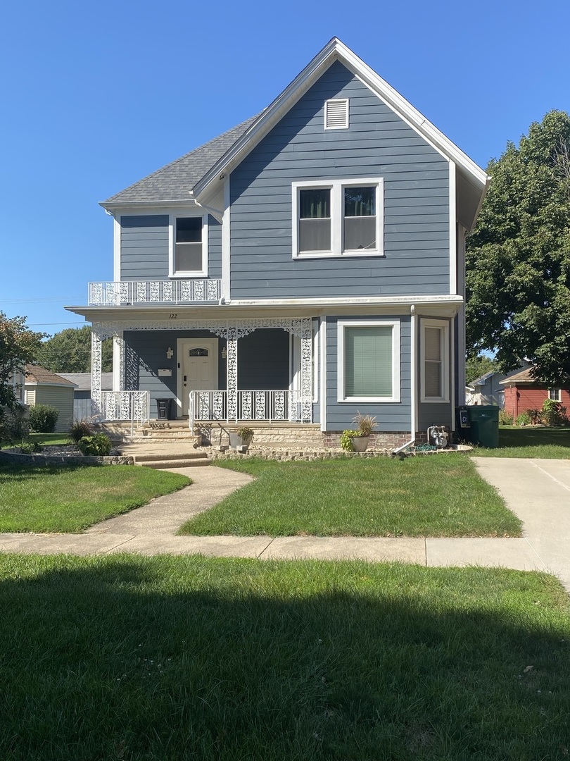 a front view of a house with a yard table and chairs