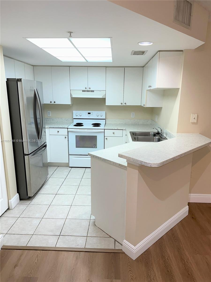 a kitchen with a stove a sink and a refrigerator