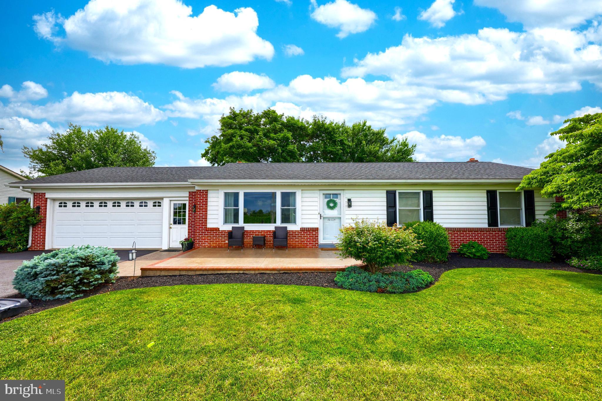 a front view of house with yard and outdoor seating