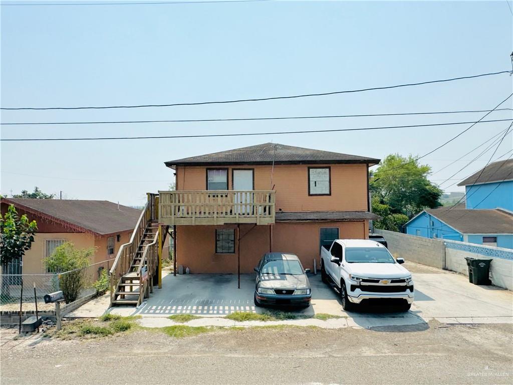 a front view of a house with cars parked