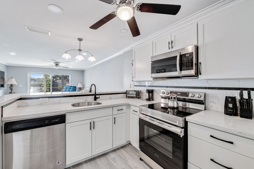 a kitchen with stainless steel appliances a stove sink and microwave