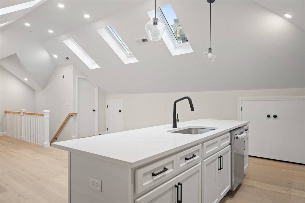 a kitchen that has a sink a stove and a wooden floor