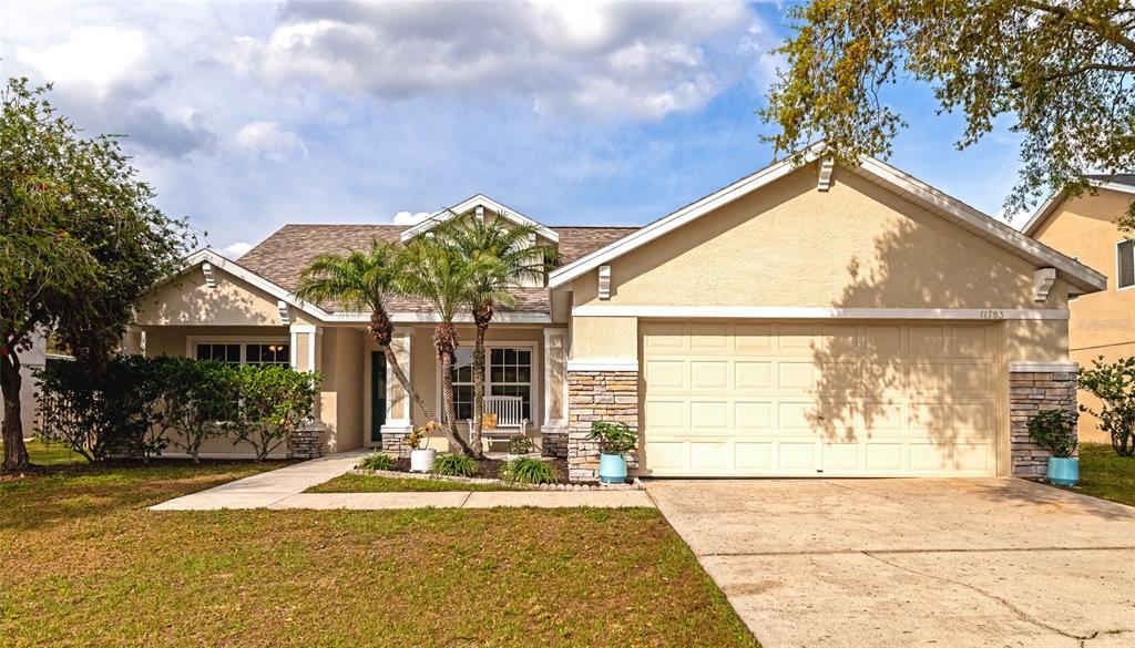 a front view of a house with a yard and potted plants