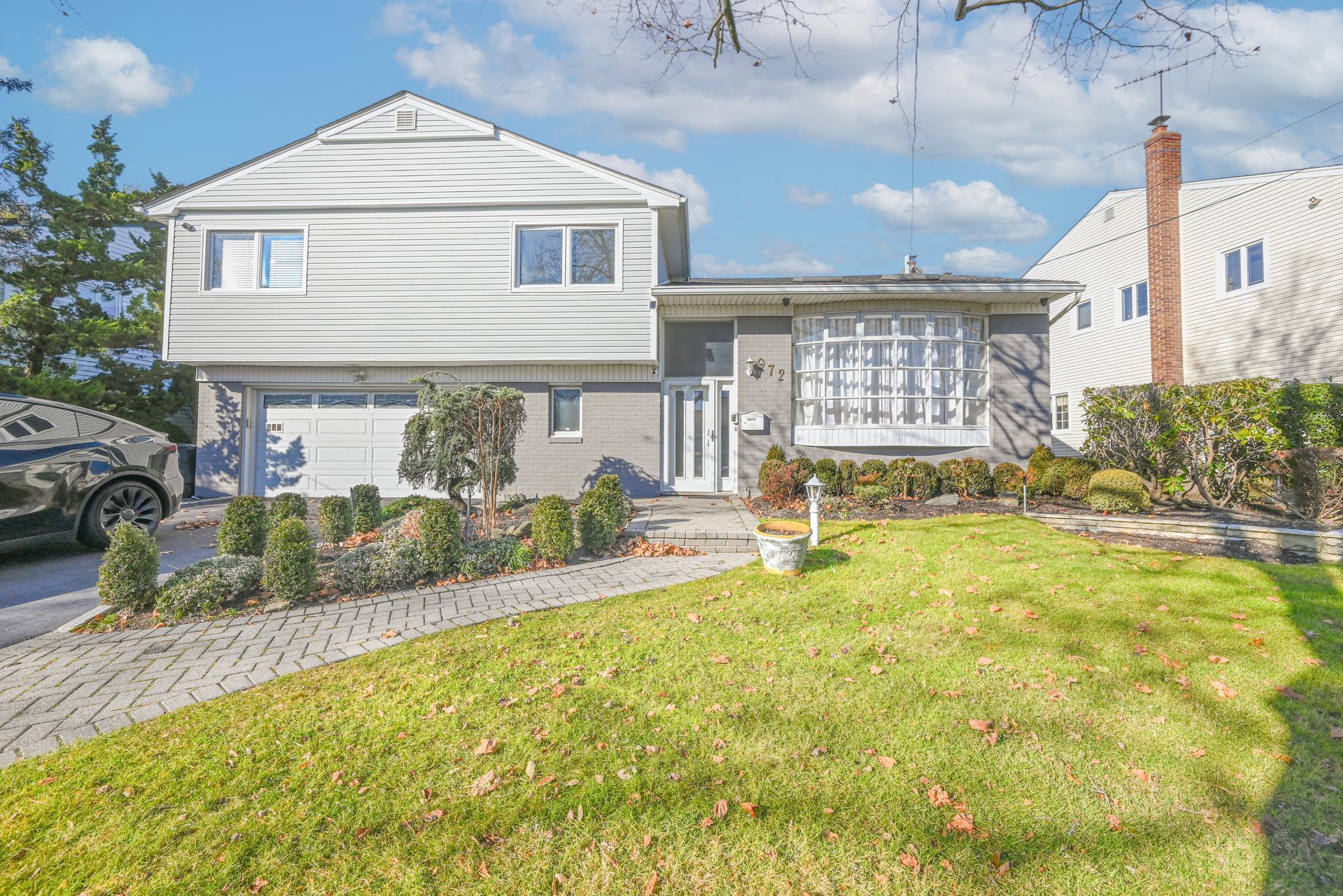 Split level home with a front yard and a garage