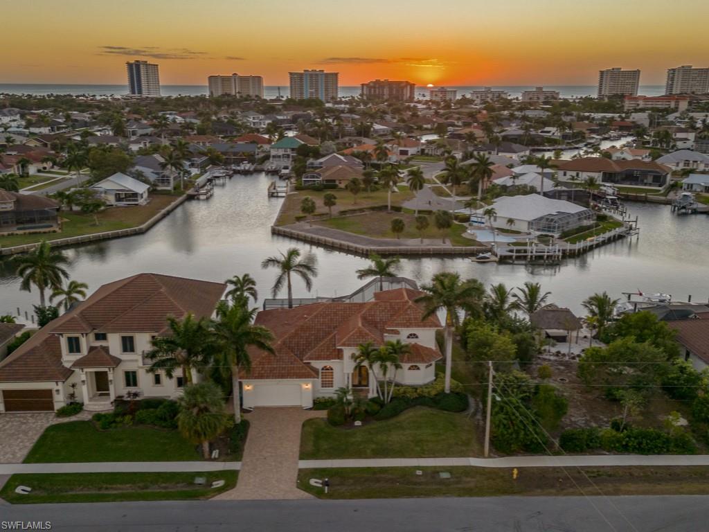 an aerial view of residential houses with outdoor space and lake view