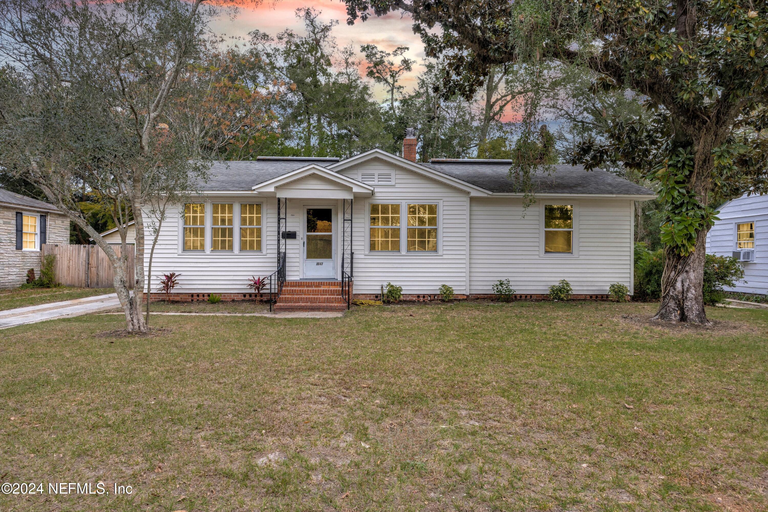 a front view of a house with a garden