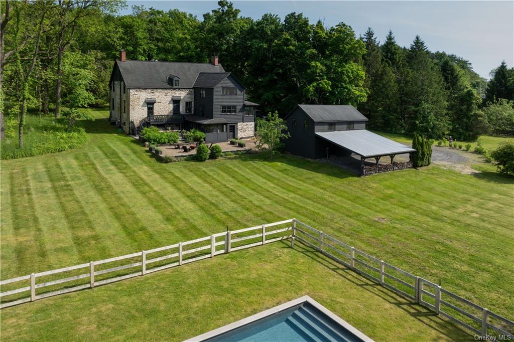 a view of a house with pool and chairs