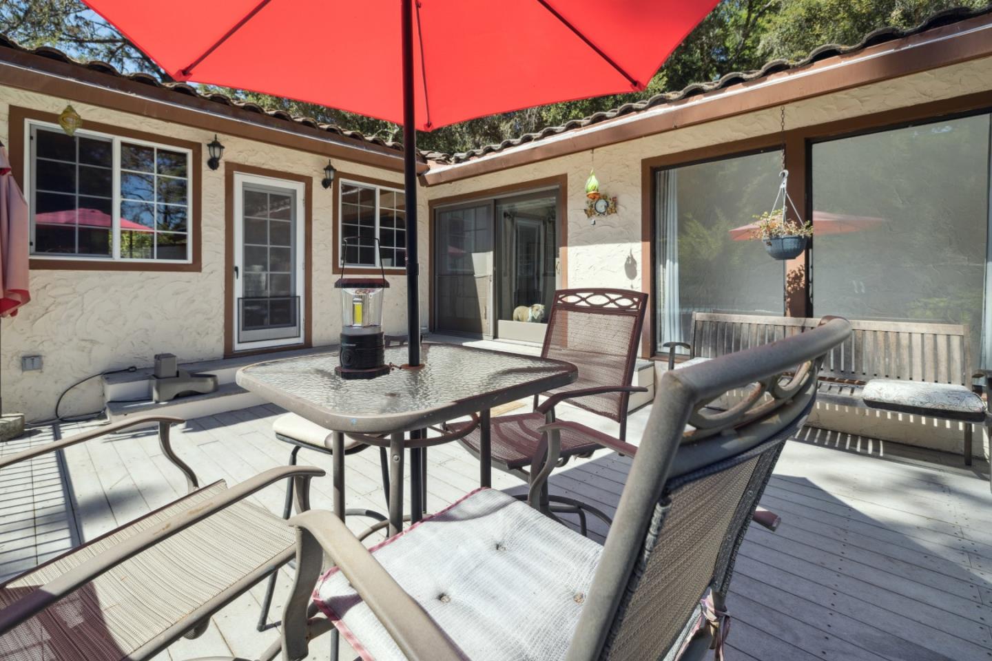 a view of a patio with table and chairs with wooden floor and fence