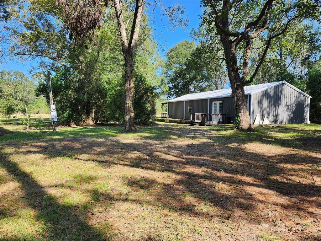 a view of a house with backyard and trees