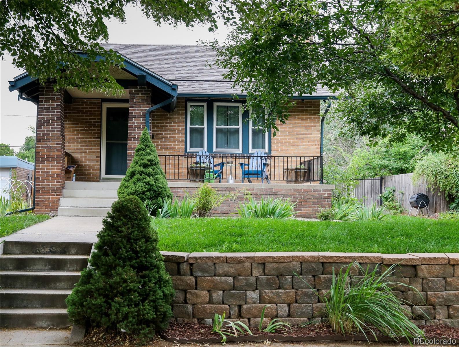 a front view of a house with a yard and potted plants