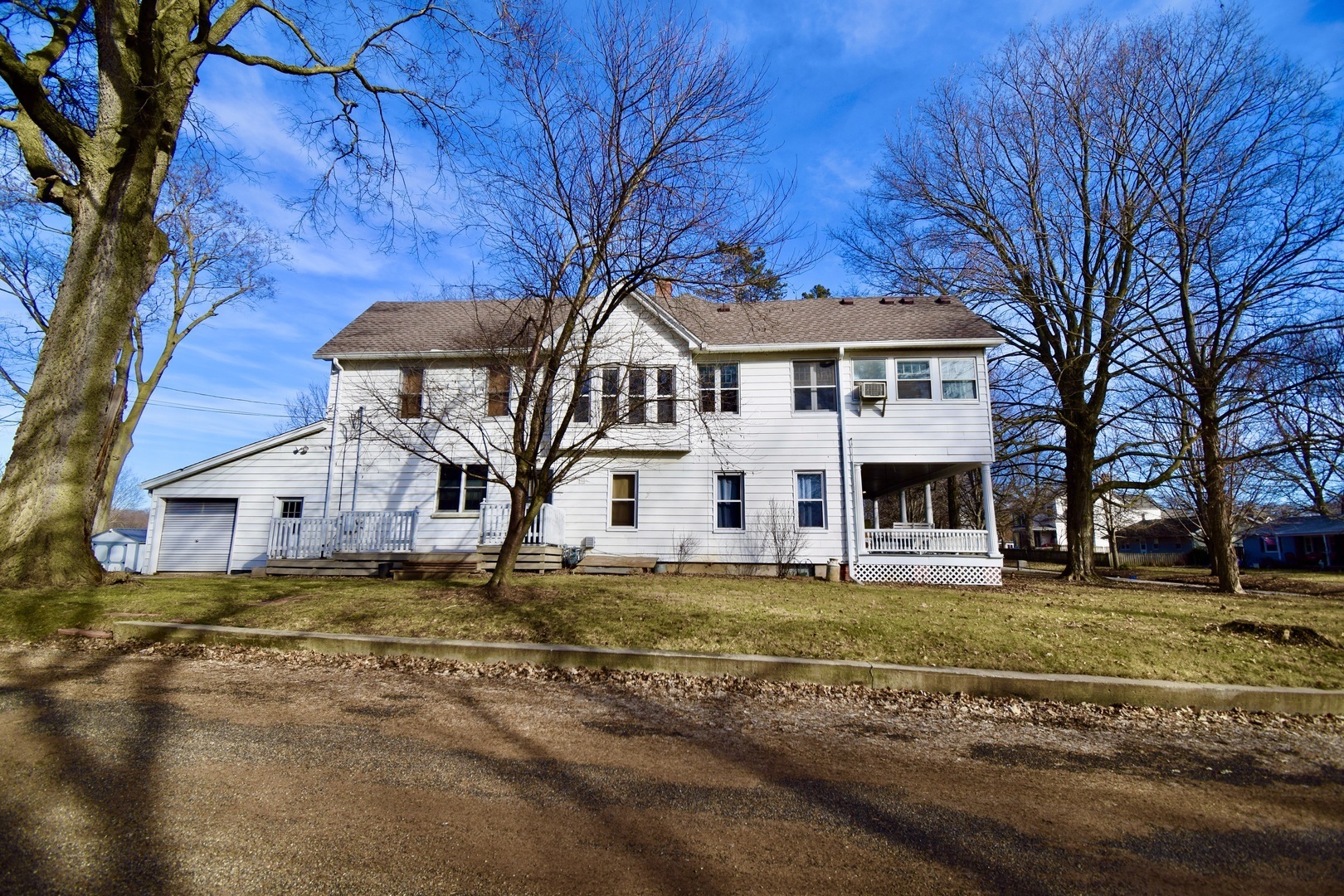 a view of a big house with a big yard and large trees