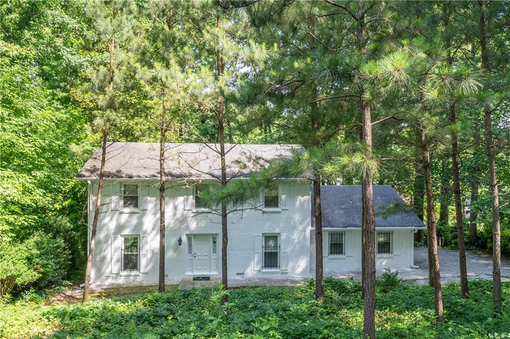 aerial view of a house with a yard and large trees