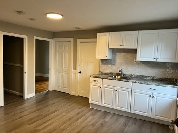 a kitchen with granite countertop white cabinets and stainless steel appliances