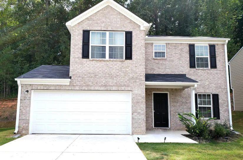 a front view of a house with a yard garage and outdoor seating