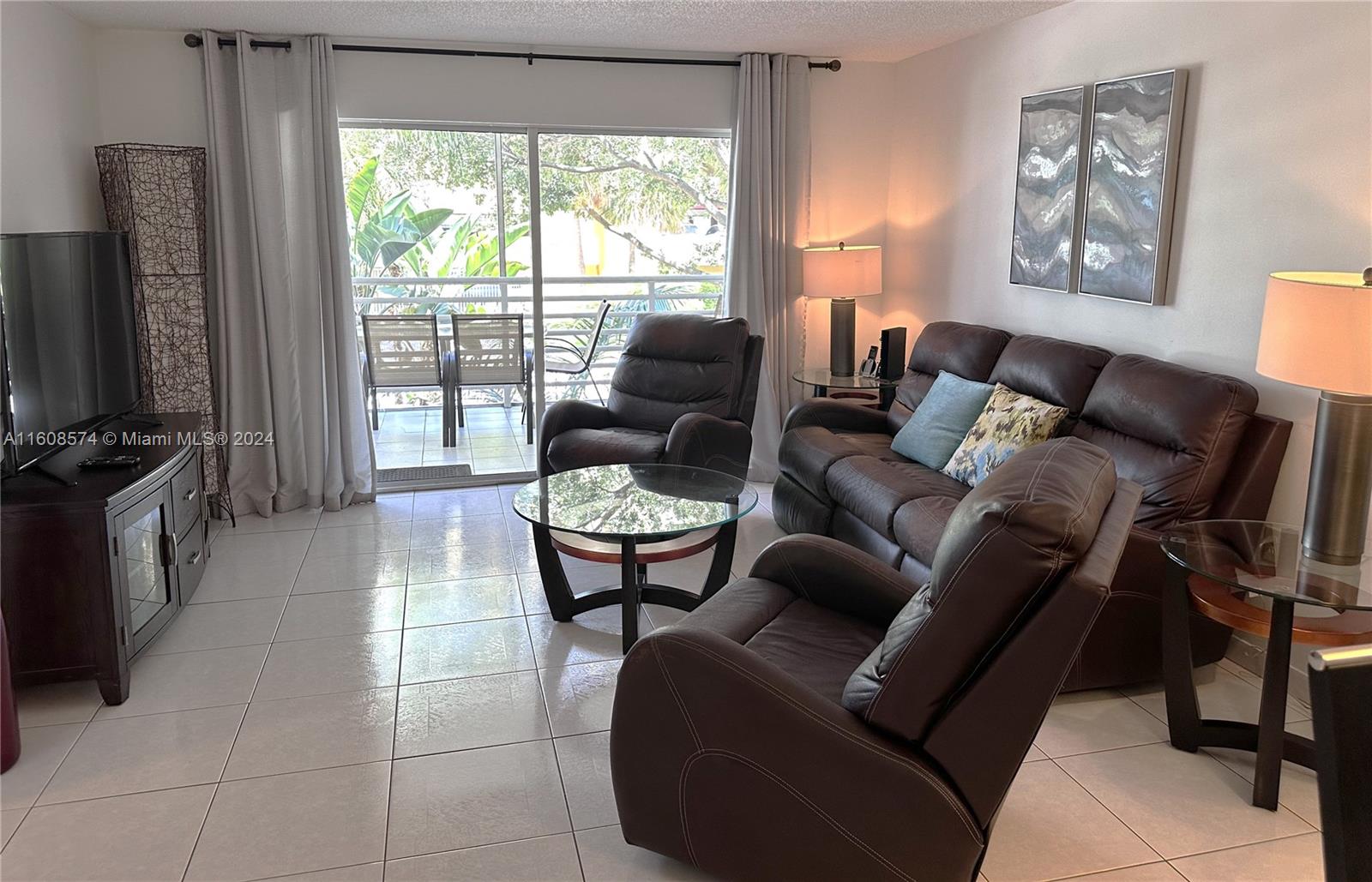 a living room with furniture a flat screen tv and a window