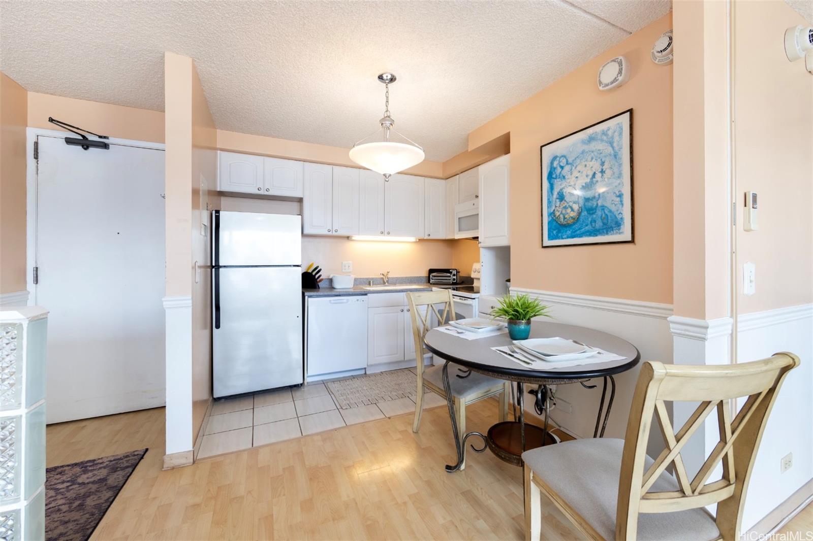 a kitchen with a table chairs refrigerator and a sink