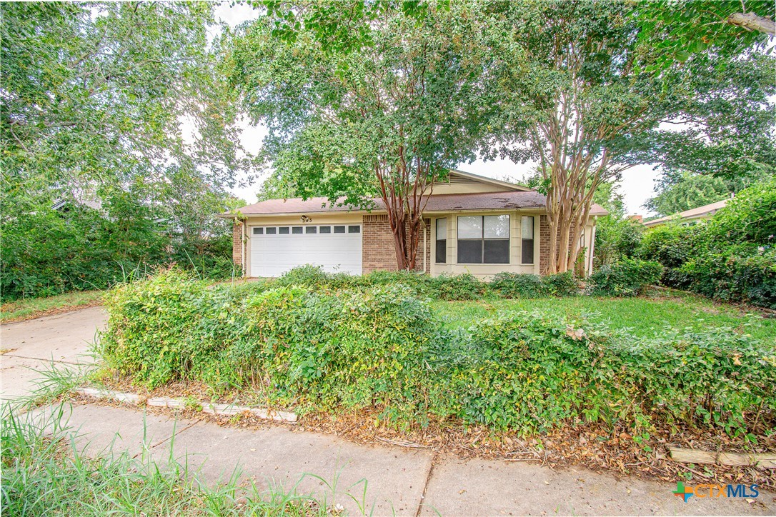 a front view of a house with a yard and fountain in middle